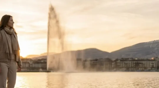 Femme voyageuse contemplant le lac Léman depuis les quais de Genève avec le jet d'eau en arrière-plan