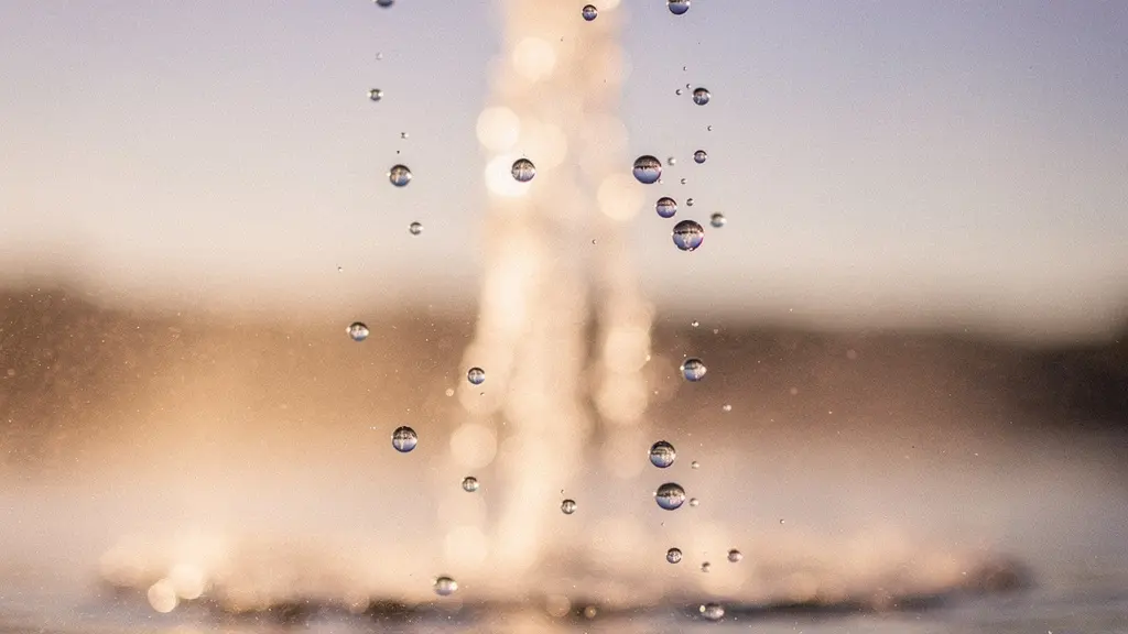 Gouttelettes d'eau en suspension captées en gros plan à contre-jour devant un ciel crépusculaire au-dessus d'un lac alpin